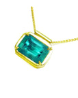 Natural Muzo Colombian emerald solitaire in 18K yellow gold, east-west orientation.