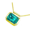 Natural Muzo Colombian emerald solitaire in 18K yellow gold, east-west orientation.