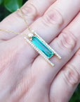 Emerald baguette cut necklace with natural diamonds, 14K yellow gold, and sliding tube bail chain.
