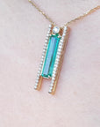 lady's gold emerald and diamond necklace with a green gemstone pendant on a woman's collar