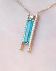 14K yellow gold necklace with a baguette-cut emerald and natural diamond accents.