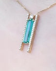 14K yellow gold necklace with a baguette-cut emerald and natural diamond accents.