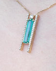 14K yellow gold necklace with a baguette-cut emerald and natural diamond accents.