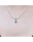 May's birthstone necklace natural Colombian emerald dangling from a wavy central bar with diamonds pave set in 14k white gold