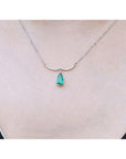 14K white gold necklace with a pear-shaped Colombian emerald and diamond-studded wavy bar.