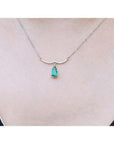 14K white gold necklace with a pear-shaped Colombian emerald and diamond-studded wavy bar.