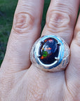 Men's black Ethiopian opal ring in sterling silver, featuring red-orange and blue hues.