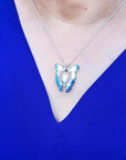 Blue agate butterfly pendant necklace with sterling silver chain on a person wearing a blue top.