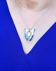 Blue agate butterfly pendant necklace with sterling silver chain on a person wearing a blue top.