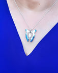 Blue agate butterfly pendant necklace with sterling silver chain on a person wearing a blue top.