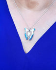 Blue agate butterfly pendant necklace with sterling silver chain on a person wearing a blue top.