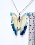 Hand-carved blue agate butterfly pendant with sterling silver frame, shown next to a ruler for size.