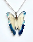 Hand-carved blue agate butterfly pendant with cream body and blue wings, set in sterling silver.