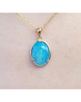 A blue opal pendant necklace on a plain skin background.