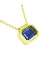 A blue sapphire choker necklace solitaire slider bezel set crafted in 14k yellow gold.