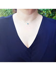 Woman wearing a 1.01 ct blue sapphire bezel-set choker on a 14K gold cable chain.