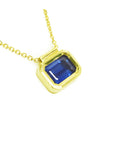 Viewing the right side of a blue sapphire choker necklace solitaire slider bezel set crafted in 14k yellow gold