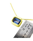 1.01 ct blue sapphire choker in a bezel setting on a 14K gold cable chain, next to a ruler.