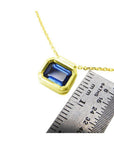 1.01 ct blue sapphire choker in a bezel setting on a 14K gold cable chain, next to a ruler.