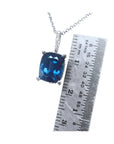 4.11 ct cushion cut deep blue sapphire pendant in 14K white gold with a ruler for scale.