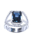 Emerald cut 4.51 ct. blue sapphire ring with a three-row diamond 18K gold band.