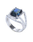 Emerald cut 4.51 ct. blue sapphire ring in 18K gold with a three-row diamond band.