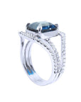 18K white gold ring with a 4.51 ct emerald-cut blue sapphire and a three-row diamond band.