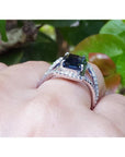 4.51 ct emerald cut blue sapphire ring with a three-row diamond band in 18K gold.