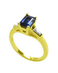 14K yellow gold ring with a rectangular emerald-cut blue sapphire and tapered baguette diamonds.