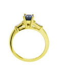 1.13 ct. emerald-cut blue sapphire ring with tapered diamonds in 14K yellow gold.