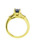 1.13 ct. emerald-cut blue sapphire ring with tapered diamonds in 14K yellow gold.