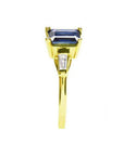14K yellow gold ring with a rectangular emerald-cut blue sapphire and tapered baguette diamonds.