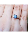 Women's 14K yellow gold ring with a rectangular blue sapphire and tapered baguette diamonds.