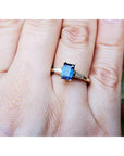 Women's 14K yellow gold ring with a rectangular blue sapphire and tapered baguette diamonds.