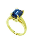 3.13 ct. deep blue emerald cut sapphire solitaire ring in 14K yellow gold.