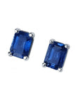 Pair of emerald-cut deep blue sapphire stud earrings in 14K white gold, prong set.