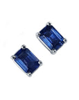 Pair of emerald-cut natural deep blue sapphire solitaire stud earrings in 14K white gold, four-prong setting.