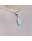 Necklace with a teardrop-shaped pendant on a person's neck