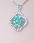 Dam's neck enlarged view of a white gold emerald cluster necklace, 4-leaf clover design accented by natural diamonds