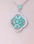 14K white gold cluster necklace with natural Colombian emeralds and diamond 4-leaf clover silhouette.