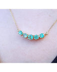 14K gold necklace with five sparkling round-cut green fire emeralds.