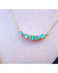 14K gold necklace with five sparkling round-cut green fire emeralds.