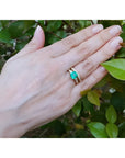 1.62 ct. emerald bridal ring with matching diamond wedding band on a hand.