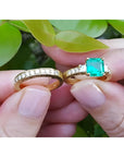 14K gold bridal emerald ring with princess-cut side diamonds and matching diamond wedding band.