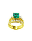 Gold ring with a natural emerald and diamonds wedding band match on a white background.