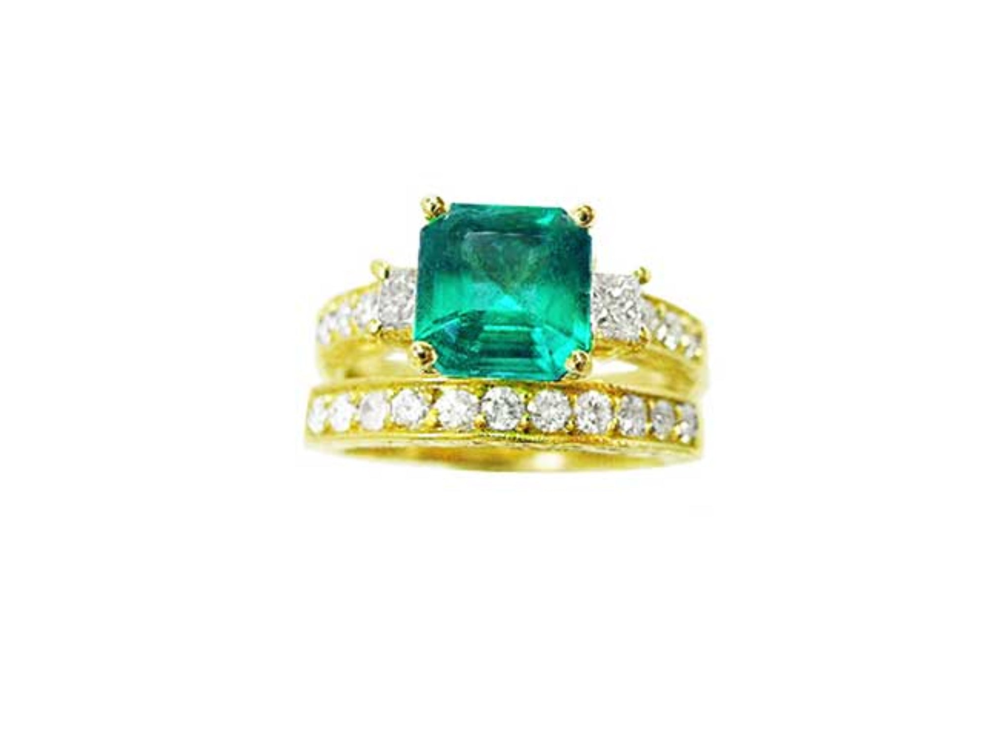 A top view of an emerald ring with accent diamonds and matching band in yellow gold, sideways profile.
