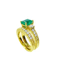 14K gold bridal emerald ring set with a sparkling green emerald and princess-cut side diamonds.