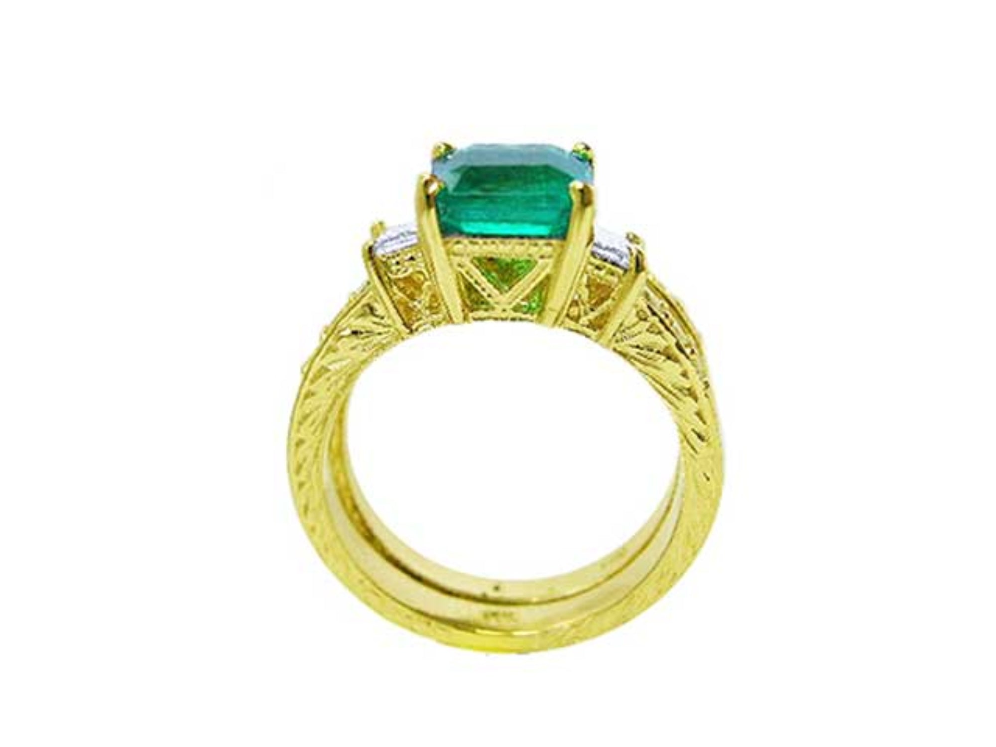 A lateral view of a natural emerald ring bridal style, top setting, gallery and band ring visibles.