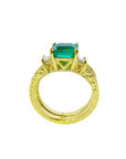 A lateral view of a natural emerald ring bridal style, top setting, gallery and band ring visibles.