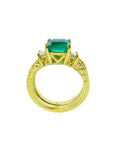 14K yellow gold bridal emerald ring with princess cut diamond accents and matching engraved wedding band.